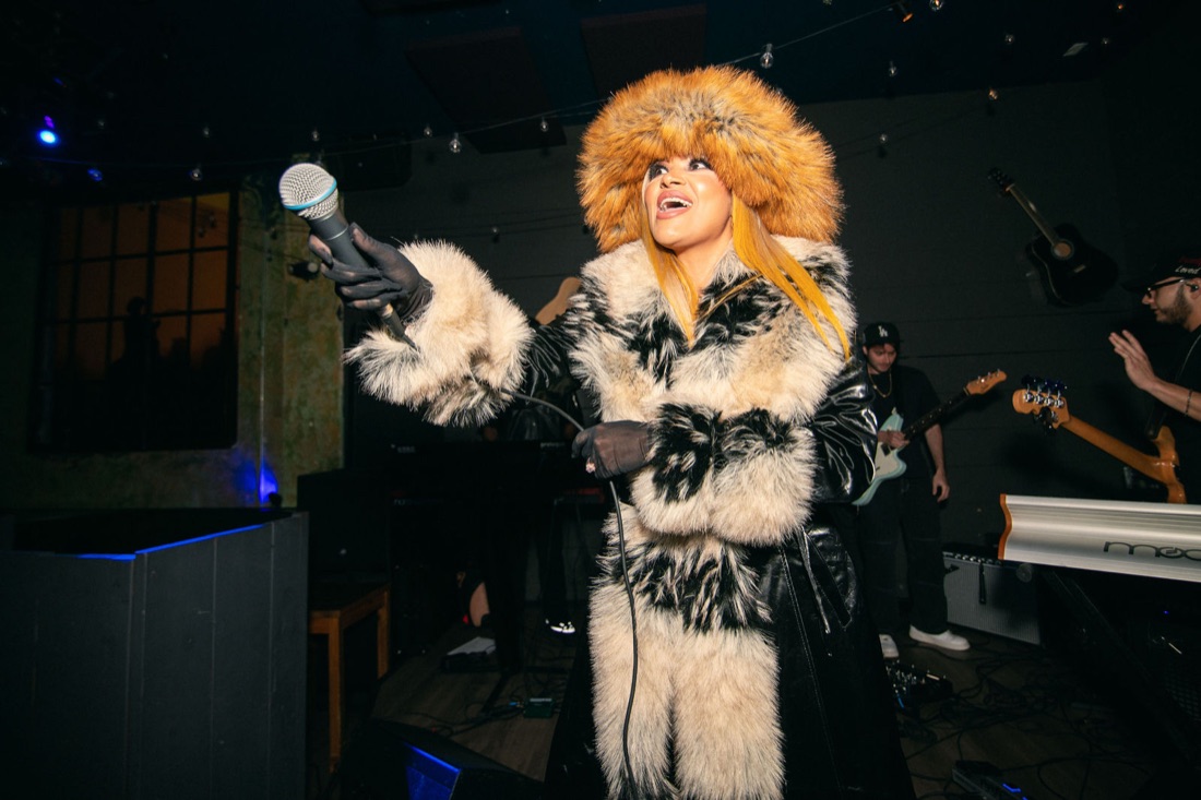 Melanie Halfkenny onstage in full fur ensemble with the live band behind her — photo by Joren Photography