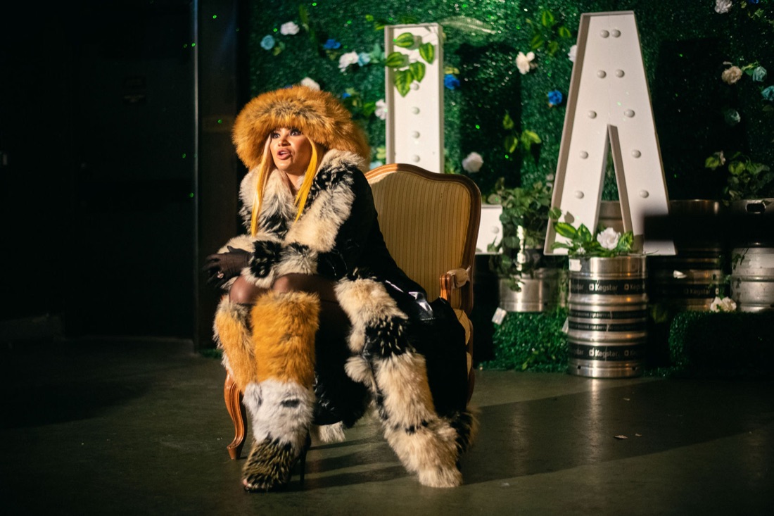 Melanie Halfkenny seated regally beside the white LA marquee letters in head-to-toe fur — photo by Joren Photography